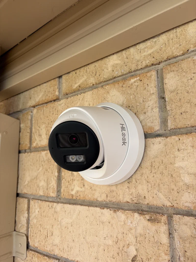 Security camera mounted on an exterior brick wall